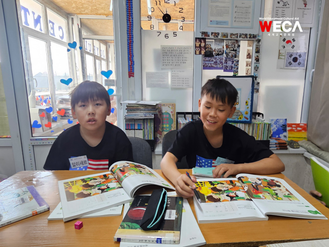 한국어 초대장 쓰기 수업에 몰두하여 연필을 쥐고 한 글자씩 정성스럽게 한글을 적어나가는 조이플센터 아이들의 모습