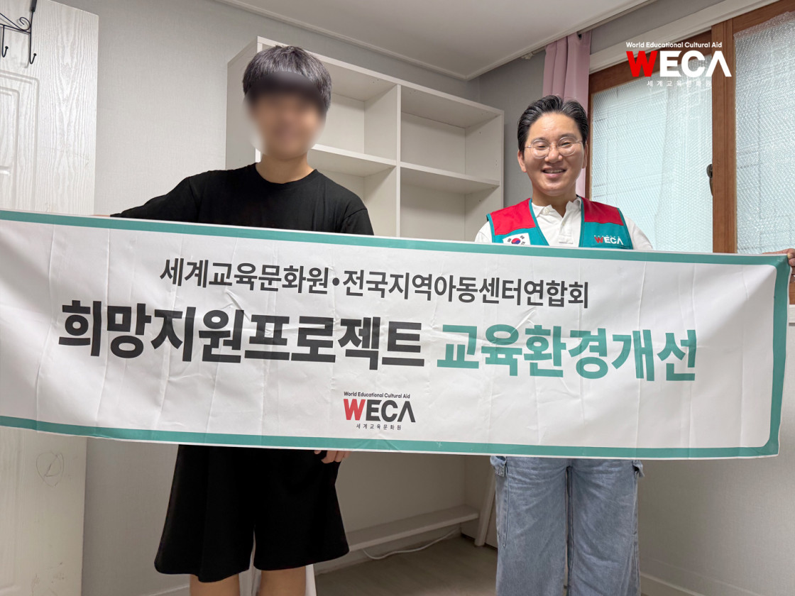 세계교육문화원과 전국지역아동센터연합의 희망지원프로젝트 교육환경개선 현수막을 들고 환하게 웃고있는 지역아동센터 청소년과 전국지역아동센터 연합회 회장