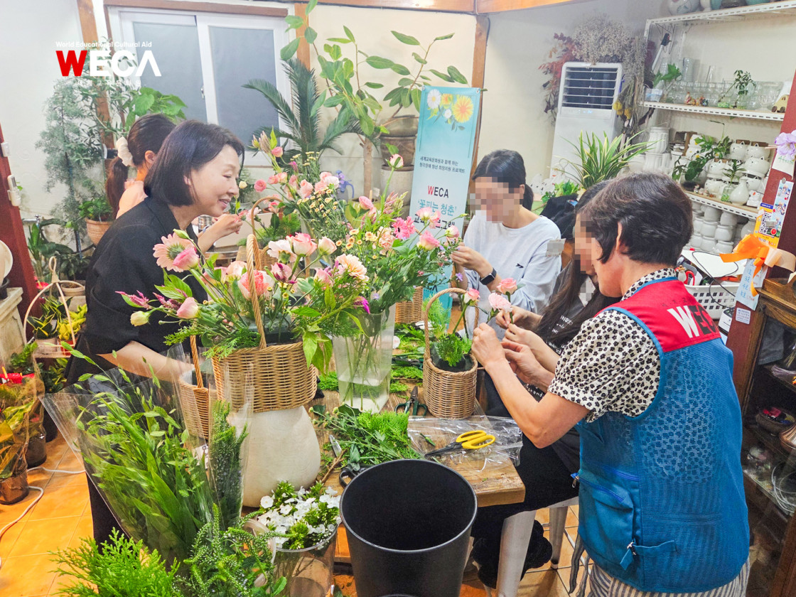 세계교육문화원 WECA 꽃피는 청춘 2회기 수업에서 청각장애 청년이 수어통역사의 설명을 들으며 꽃바구니에 생화를 꽂는 모습