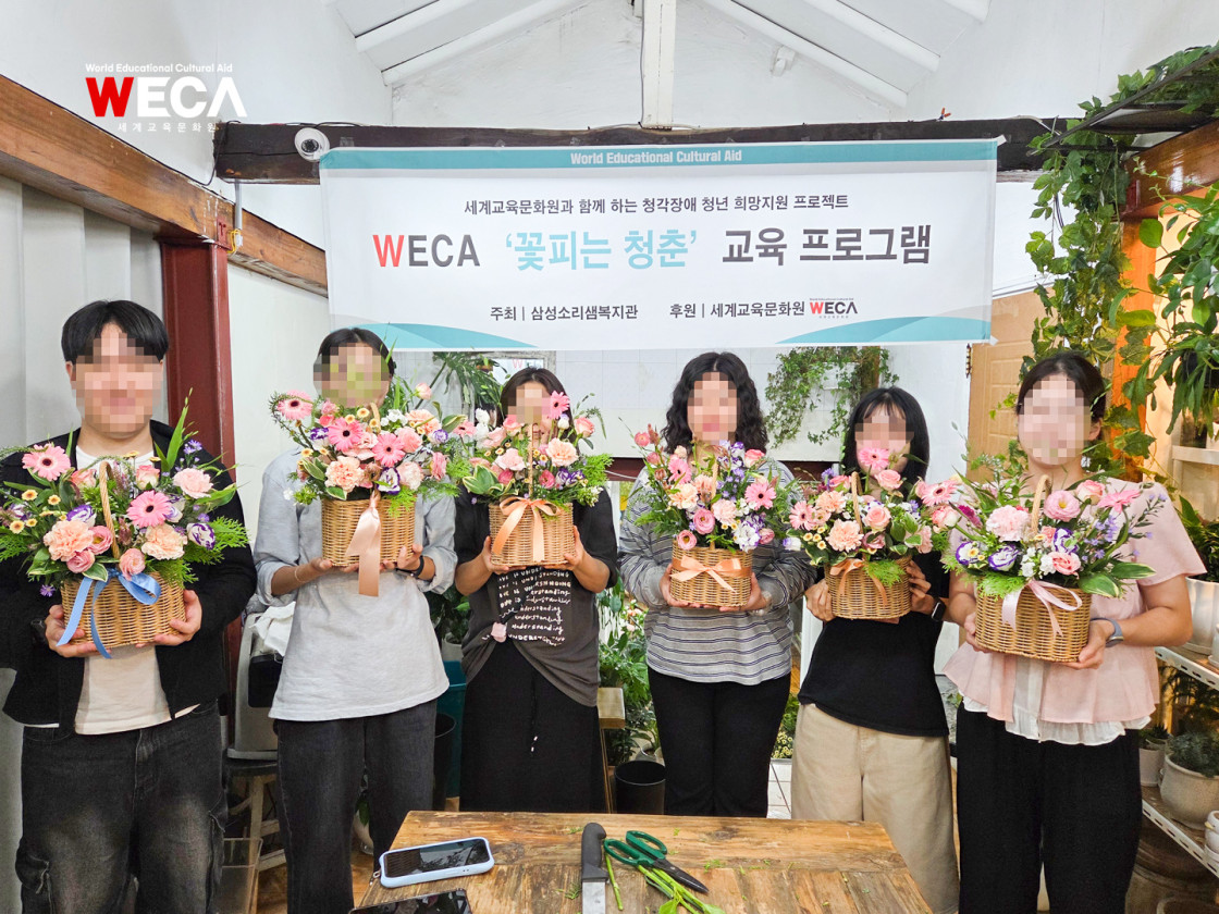 직접 정성을 담아 완성한 기념일용 플라워 바스켓을 앞에 두고 환하게 웃고 있는 청년들의 모습